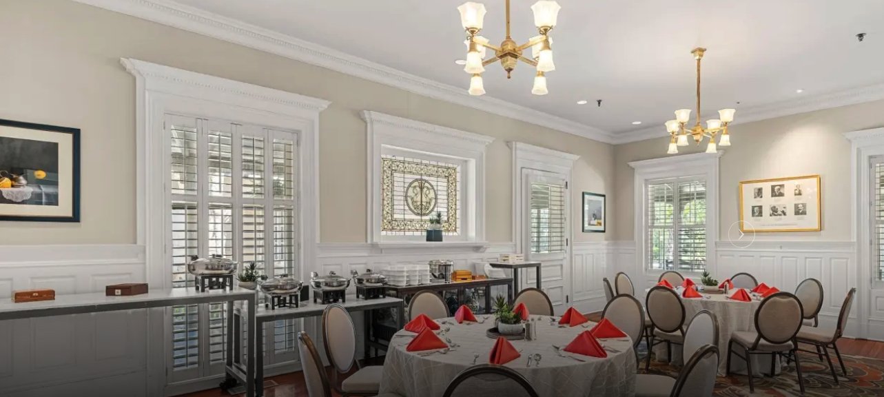 The Federal Reserve Room at the Jekyll Island Club Resort, with chandeliers, white wainscoting, and a stained-glass window